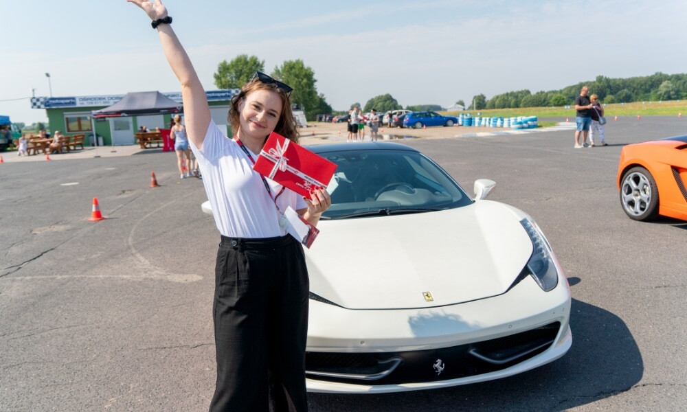 dziewczyna trzymająca voucher prezentowy na jazdę po torze